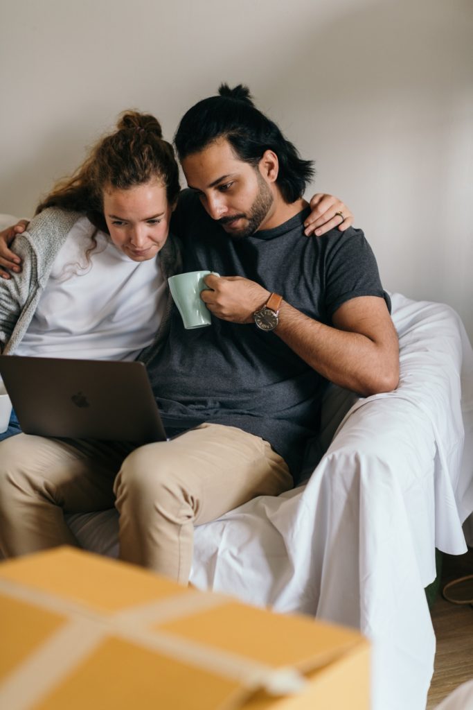 A couple looks at down payment rates on their laptop.