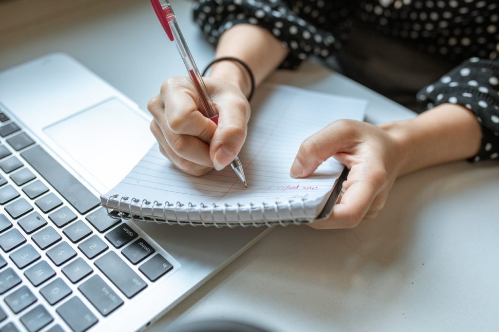 A woman takes notes about negotations.