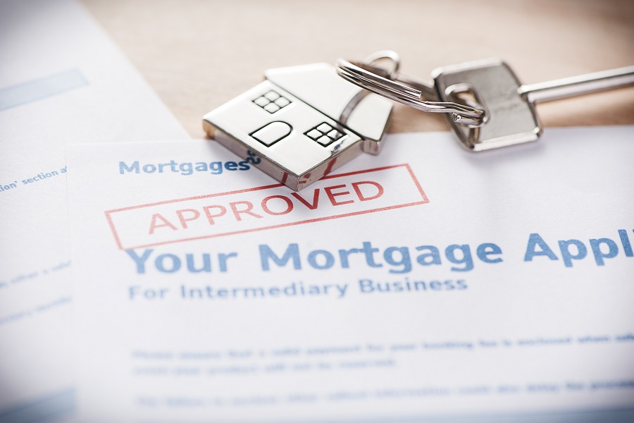 paperwork stating that your mortgage rate has been approved, with a metal house keychain