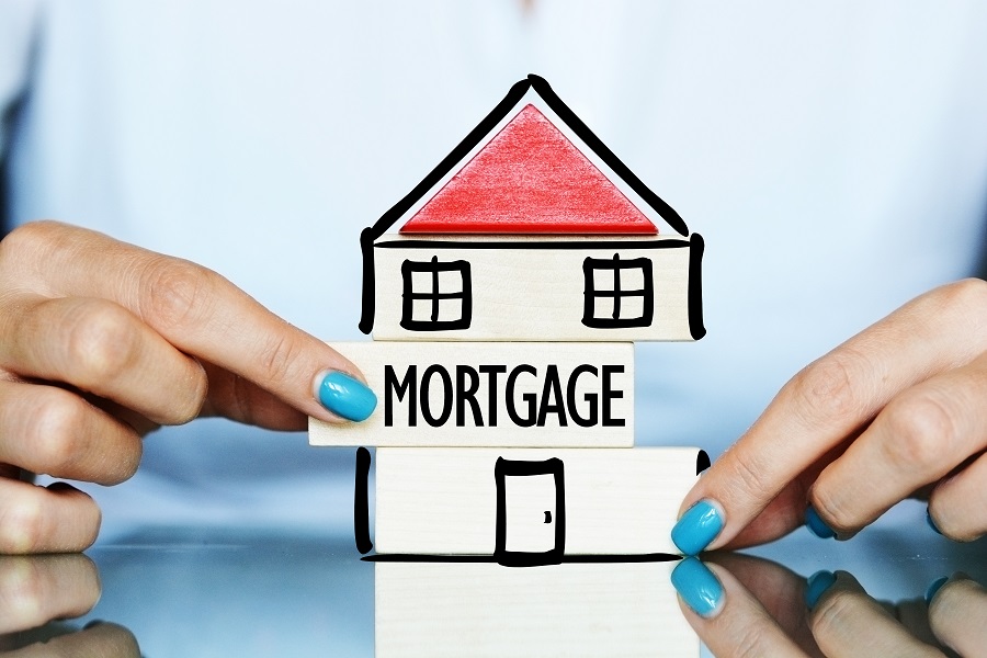 person holding drawing of a house made of mortgage