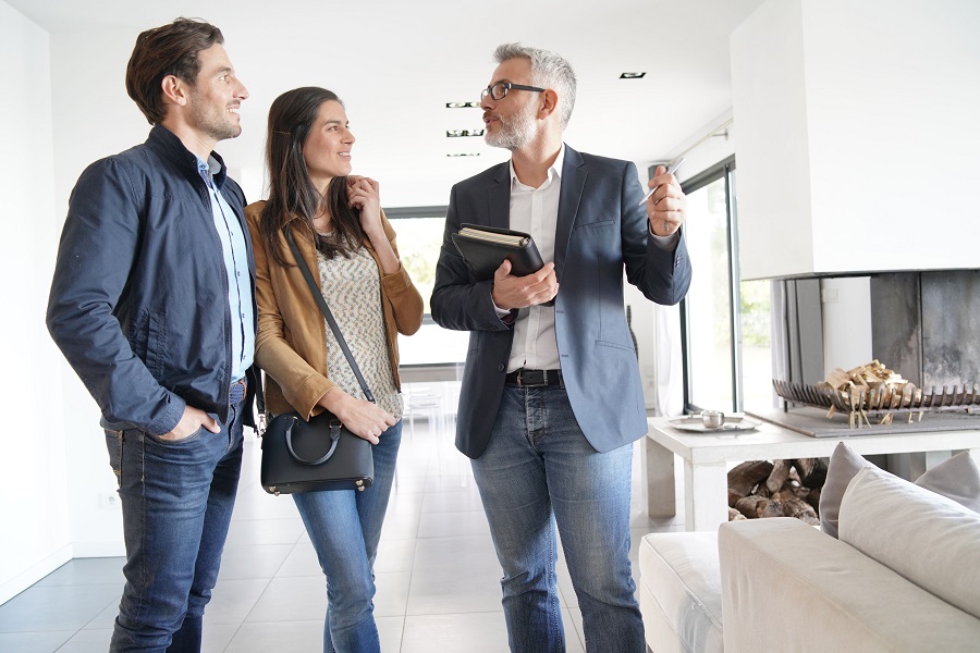 Potential buyers talking to a real estate agent in a house.